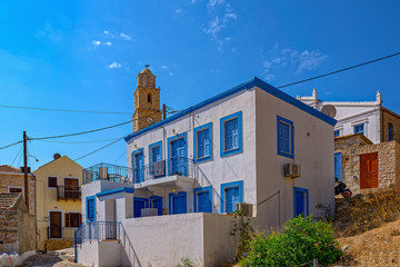 Fototapeta na wymiar Typical white and blue color Greek house in coastal town on the Greek island of Halki.
