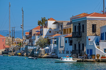 Fototapeta na wymiar Scenic view of colorful houses on embankment of coastal town, Chalki Island.