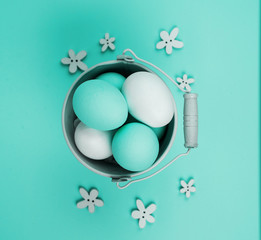 Series of eggs painted white and blue, in a small pail, buctet. Spring and Easter holiday concept.