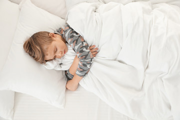 Cute boy sleeping in bed, above view