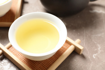 Cup of Tie Guan Yin oolong tea on table, closeup