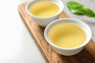 Stand with cups of freshly brewed oolong tea on table, space for text