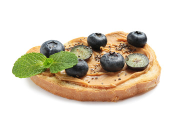 Tasty toast with blueberries, peanut butter and chia seeds on white background