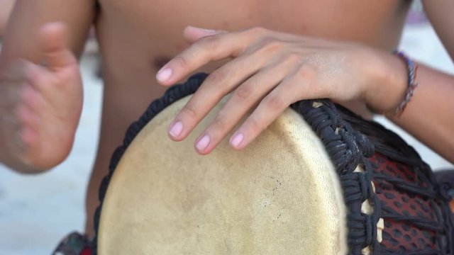 Man musician playing on a Bongo drum close up. Hand tapping a Bongo drum. Drummer hands, movement, rhythm. Koh Phangan island, Thailand