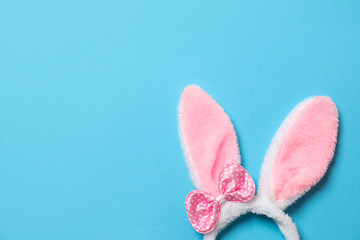 Funny headband with Easter bunny ears on color background, top view. Space for text