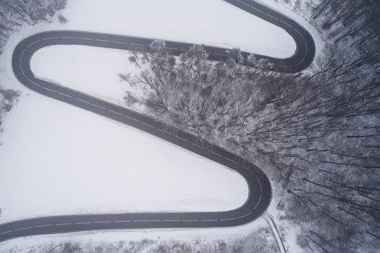 Austria, Wienerwald, winding road in snow-covered landscape, aerial view