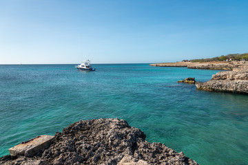 Fishing yacht anchored near the shore on a beach in Aruba. These boats are common to see on the...