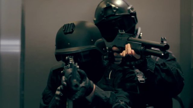 Two commandos with weapons out of the elevator