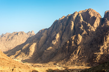 Naklejka na ściany i meble Middle East or Africa, picturesque bare mountain range and a large sandy valley desert landscapes landscape photography