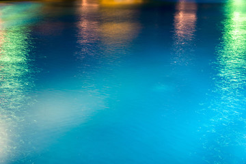 Abstract background, texture of blue water with multicolored highlights on it