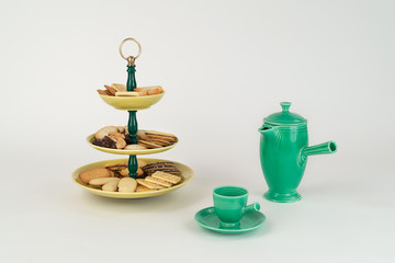 Naklejka na ściany i meble Three Tier Mid-Century Modern Serving Dish with Yellow Glazed Plates and Green Bakelite Stem with Brass Ring Handle for Desserts or Appetizers with Coffee Carafe and Demitas Cup and Cookies