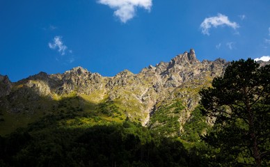 Fototapeta na wymiar Mountains and the nature of the North Caucasus, the blue sky over high rocks in the beautiful gorge