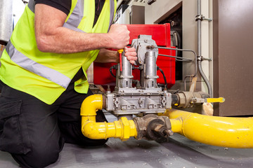 Gas engineer fitting a valve to an industrial boiler
