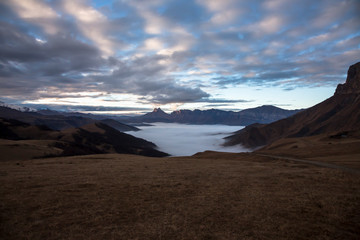 Fog in the mountain gorge, high rocks over clouds. nature of the North Caucasus