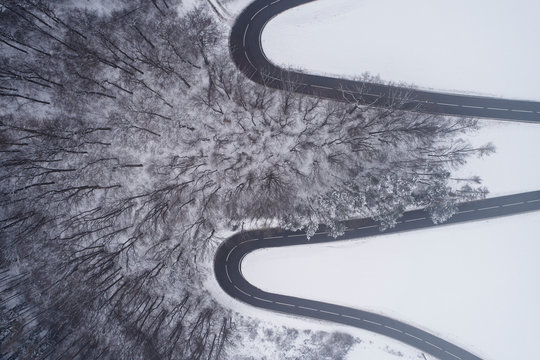 Austria, Wienerwald, winding road in snow-covered landscape, aerial view