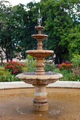 Fototapeta premium Bringing the soft sounds of falling water, a beautiful tiered water fountain is a joyful addition to any garden.