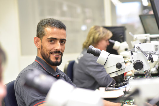 Portrait of smiling man working on quality control in the manufacturing of circuit boards for the electronics industry