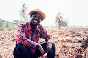 Naklejka na ściany i meble Portrait of african farmer man sitting at the field