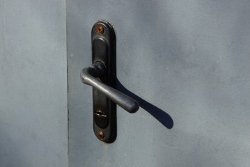 black door knob on a gray metal door