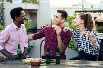 Group of young friends with pizza and bottles of drink