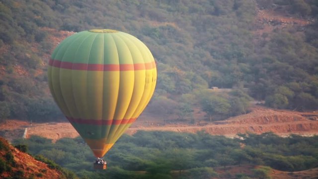 Balloon rises to the sky in the fog in the mountains