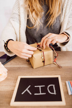 Young woman wrapping a gift in her studio