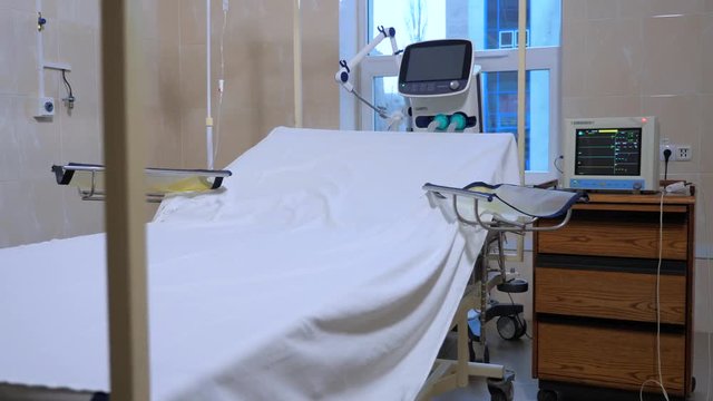 Fully-equipped postoperative ward in the hospital. Empty Hospital bed covered with white sheet. Preparation for surgery. Room for preparing a patient for surgery.