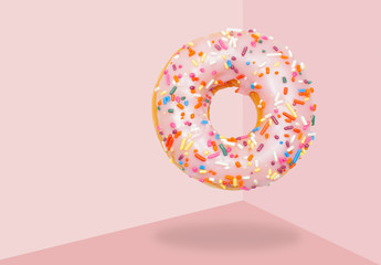 Pink donut on on pastel pink background.