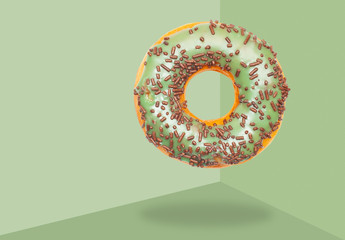Green donut on on pastel green background.