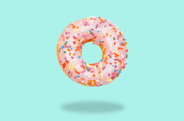 Pink donut on on pastel green background.