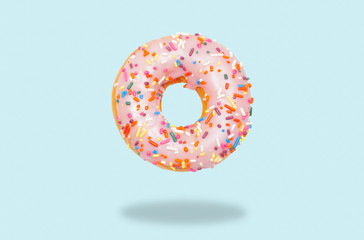 Pink donut on on pastel blue background.
