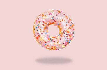Pink donut on on pastel pink background.