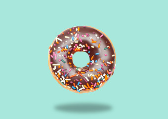 Chocolate donut on pastel green background.