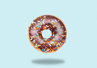Chocolate donut on pastel blue background.