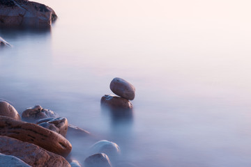 zen stones in the water in sea in korbeus at sunset