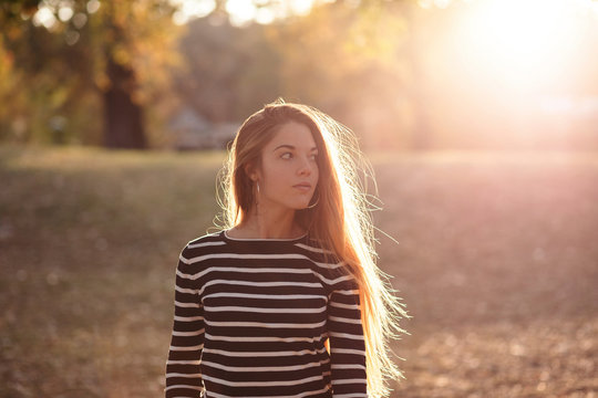 Portrait of young woman in a park at sunset