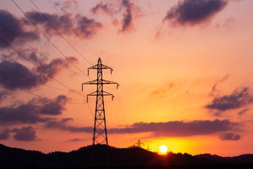 沈む太陽と送電線の鉄塔　夕焼け　空　美しい風景