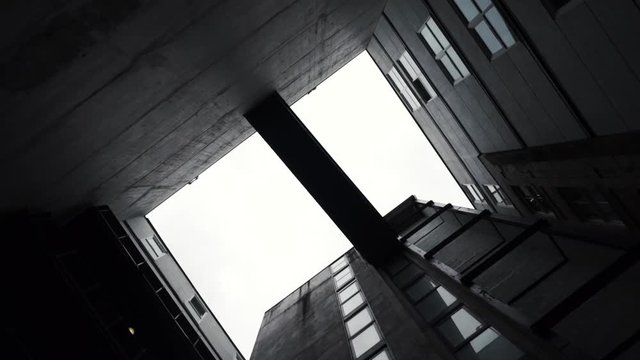 Looking up at bridge several stories up surrounded by buildings