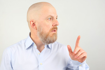 bearded man in blue shirt shows index finger up