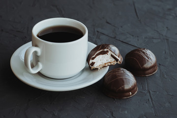 Chocolate cakes and cup of coffee on dark background
