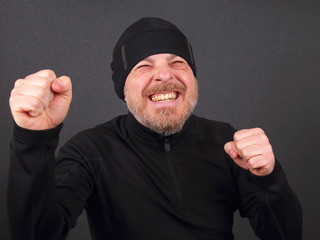Emotional bearded man with clenched hands in pursuit of victory
