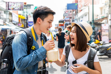 Happy Asian couple tourist backpackers traveling in Khao San road ,Bangkok