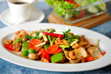 Stir Fried Sweet Vegetables in a White Plate Broccoli, carrots, corn, mushrooms, chili, cabbage on blue background 