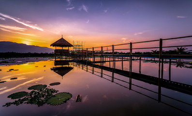 Twilight at the reservoir with silhouette bamboo pavilion and reflection in sunset, Chiang Mai in Thailand