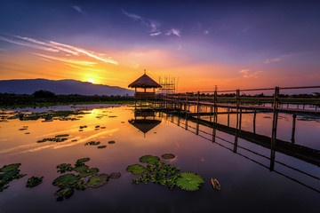 Twilight at the reservoir with silhouette bamboo pavilion and reflection in sunset, Chiang Mai in...