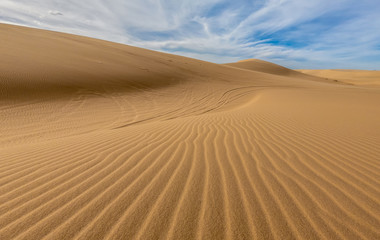 Desert sand dunes ripples in blue sky, White sand dunes in Mui Ne, Vietnam.