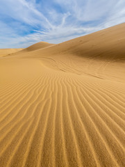 Desert sand dunes ripples in blue sky, White sand dunes in Mui Ne, Vietnam.