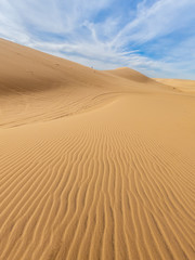 Fototapeta na wymiar Desert sand dunes ripples in blue sky, White sand dunes in Mui Ne, Vietnam.
