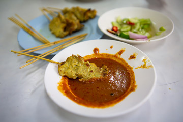 Skewer and Pork Satay with your Peanut Sauce and pickles which are cucumber slices and onions in vinegar,  Close up & Macro shot, Selective focus