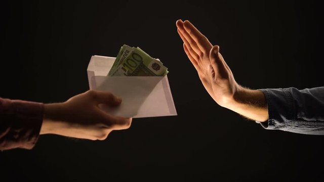Male giving envelope with euros, person making stop gesture, refusing bribe